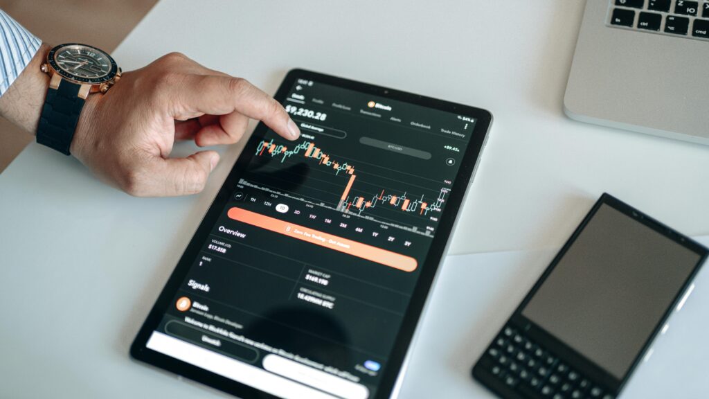 Case Study: How I Scaled a Fintech Platform to 10x User Growth A person using a tablet to view and analyze a cryptocurrency market chart indoors.